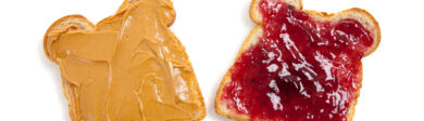 a piece of bread on the left that is spread with peanut butter and a piece of bread on the right that is spread with strawberry jelly. The background is white.